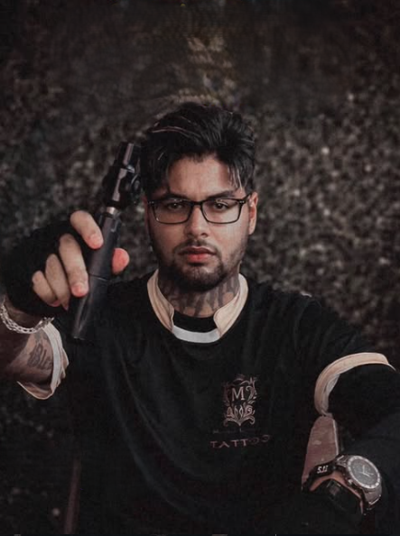 Tatuador Murilo Lourenço segurando a máquina de tatuar